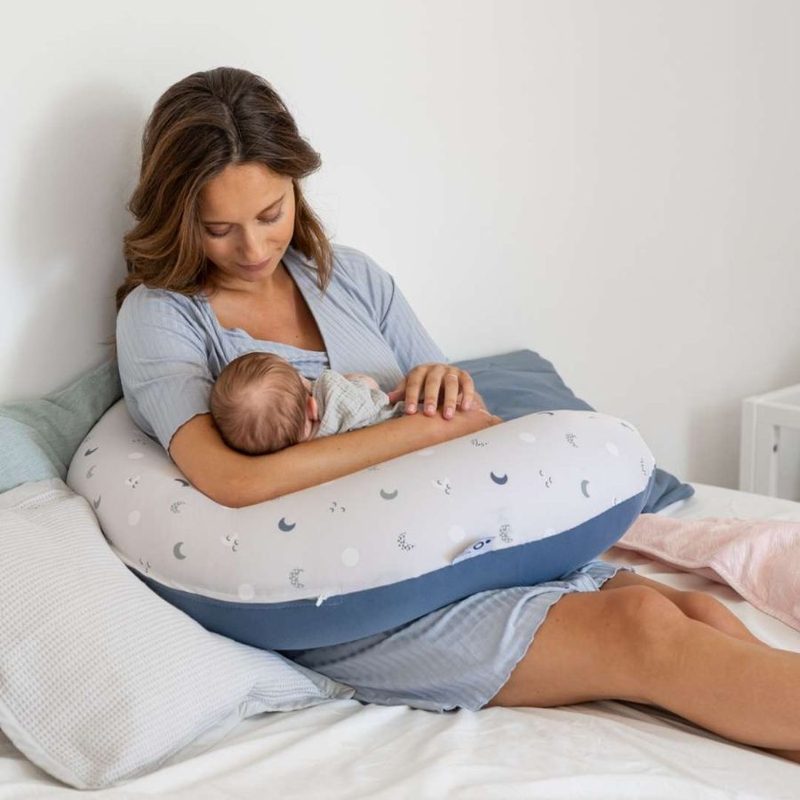 Maman qui allaite son bébé installée sur un coussin d'allaitement