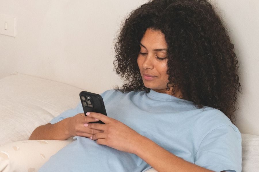Future maman qui compose sa liste de naissance sur son téléphone