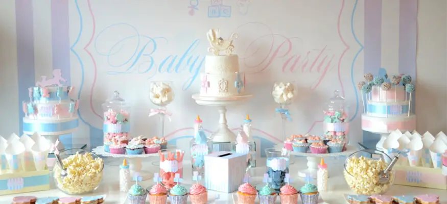 Table de baby shower en rose et bleu, avec gâteau, cupcakes et cake pops