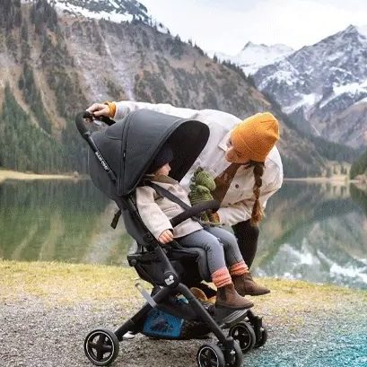 Maman qui installe son enfant dans une poussette compacte
