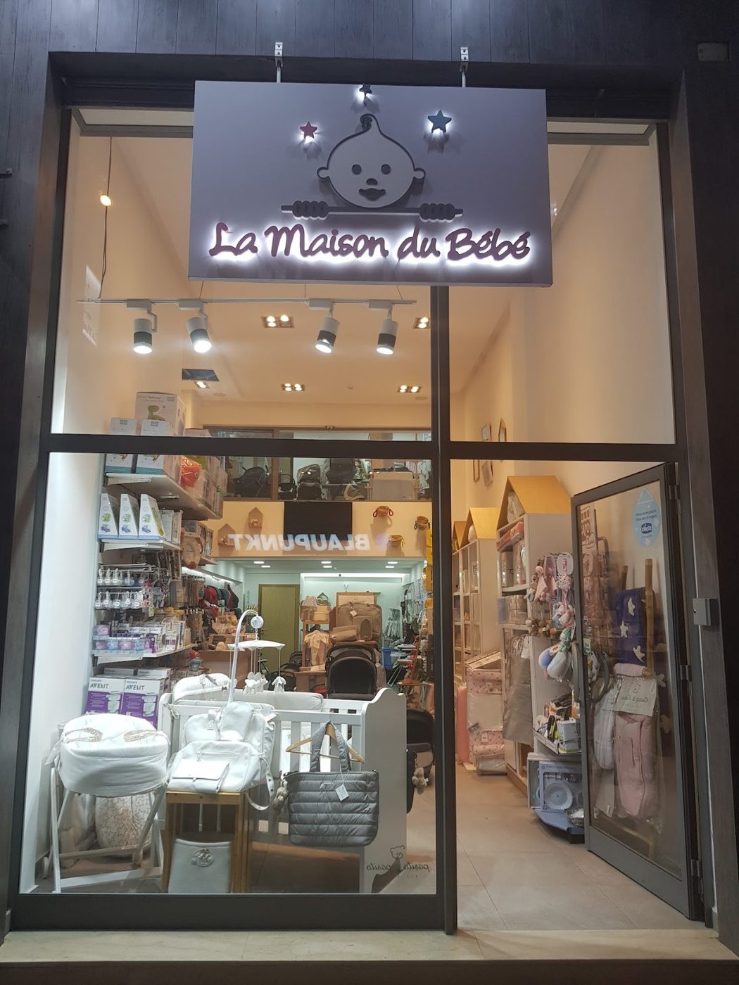Vitrine éclairée du showroom La Maison du Bébé, le soir